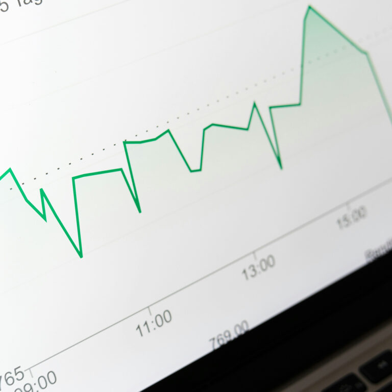 A laptop screen displays a colorful business graph, illustrating growth trends and data analysis.